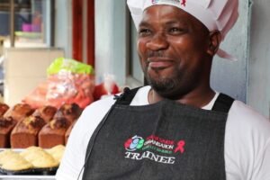 Smiling Baker with baked goods in the backround